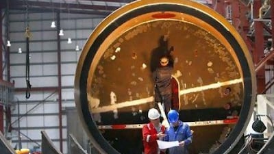 Workers install the interior of a wave energy converter at the Pelamis Wave Power site in Leith, Edinburgh, Scotland. Reuters