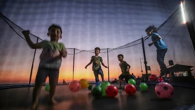 Palestinian children play on a trampoline at sunset in Gaza City. EPA