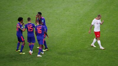 Colombia players celebrate as Poland's Kamil Grosicki looks dejected after his side's 3-0 defeat. Jorge Silva / Reuters