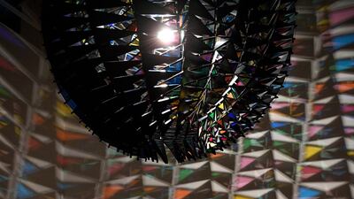 A woman poses with Danish-Icelandic artist Olafur Eliasson's work 'Cold Wind Sphere' (2012). Photo: EPA