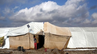 An Iraqi girl looks out from her tent after heavy rainfall caused flooding in Salamiya Camp, southeast of Mosul. EPA