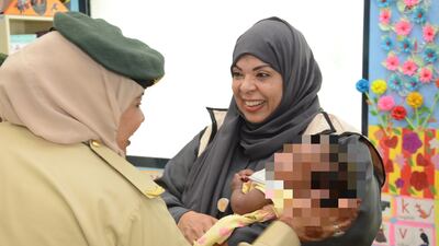 Dubai Police and Emirates Red Crescent officials with one of the children who have received winter clothing. Photo: Dubai Police