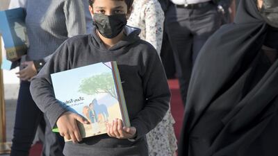 A boy with his copy of Sheikh Mohammed bin Rashid, Vice President and Ruler of Dubai's book 'My Little World' at the Emirates Airline Festival of Literature. Leslie Pableo / The National