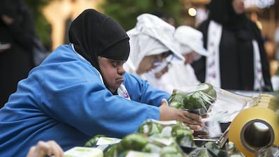 A young woman packages vegetables at one of the job stations set up at Yas Mall in celebration of Down Syndrome Day. Mona Al Marzooqi/ The National
