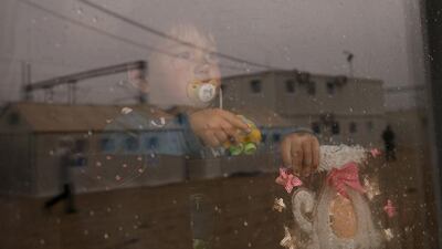A migrant child looks through a window at the Macedonian-Serbian border near the village of Tabanovce, Macedonia. Marko Djurica / Reuters