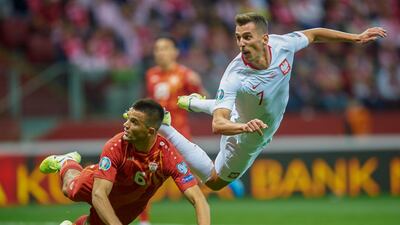Poland's forward Arkadiusz Milik vies for the ball with North Macedonian defender Visar Musliu, left, in Warsaw. AFP