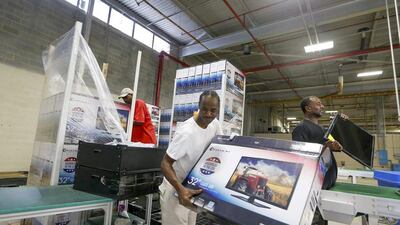 A worker stacks empty boxes after removing the shell of a 32-inch TV at Element Electronics in Winnsboro, South Carolina. Walmart pledged in 2013 to buy an extra $250 billion in US-made goods over the next decade and Element's 32- and 40-inch TVs are now available in all of the retailer's more than 4,000 US stores. Chris Keane / Reuters