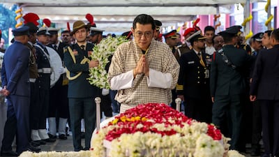 Bhutan's King Jigme Khesar Namgyel Wangchuck (C) pays last respect to India's late former Prime Minister Manmohan Singh, during the state funeral ceremony in New Delhi. India on December 28, accorded former premier Manmohan Singh, one of the architects of the country's economic liberalisation in the early 1990s, a state funeral with full military honours, complete with a gun salute. AFP