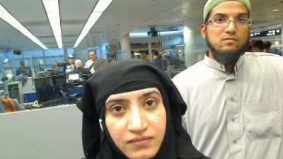 Tashfeen Malik, left, and her husband Syed Farook pictured passing through Chicago's O'Hare International Airport in this July 27, 2014 handout photo. Apple has challenged a magistrate's order to retrieve information about Farook from his iPhone. US Customs and Border Protection/Handout via Reuters