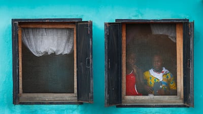Liberian girls look out a window to see presidential candidate George Weah from the Congress for Democratic Change (CDC) party as he passes in a cavalcade during a campaign rally in Buchanan, Liberia. Nic Bothma / EPA