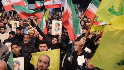 Hezbollah supporters wave Iranian and Lebanese flags at a rally in Beirut. Israel says its regular attacks are aimed at members of the group. AFP