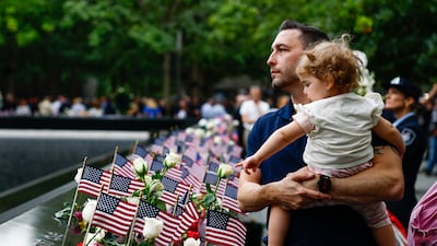 Matt Dunleavy holds his daughter Ellie during the ceremony at the 9/11 Memorial. EPA