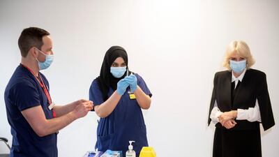 Camilla, Duchess of Cornwall, reacts as she helps staff to prepare a dose of a vaccine during a visit to a vaccination centre at Lordship Lane Primary Care Centre in London. Reuters