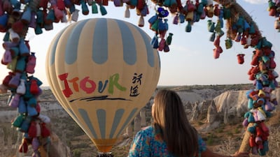 A woman watches as a sight-seeing hot air balloon is launched.