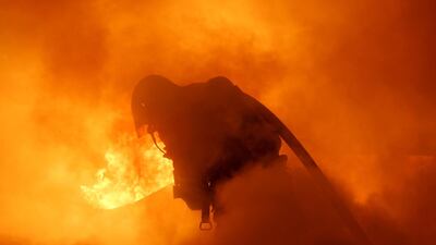 Firefighters extinguish a burning car during New Year celebrations in Douai, northern France. Reuters