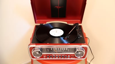 The record player fits into the apartment's red and white colour scheme