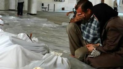 A Syrian couple mourn in front of bodies wrapped in shrouds ahead of funerals following a toxic gas attack in Eastern Ghouta on the outskirts of Damascus.