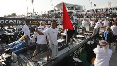 Adil Khalid raises the national flag after Abu Dhabi Ocean Racing crew finish first the In-Port Race on Friday.