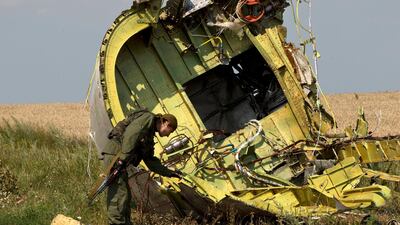 In this July 22, 2014 file photo, a rebel fighter touches the MH17 wreckage at the crash site of Malaysia Airlines Flight 17, near the village of Hrabove, eastern Ukraine. AP Photo