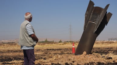 A Syrian farmer looks at an Iranian missile that fell into agricultural land. AFP