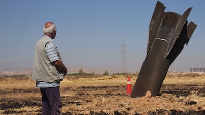 A Syrian farmer looks at an Iranian missile that fell into agricultural land. AFP