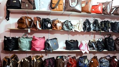 Counterfeit handbags designed by Louis Vuitton and Chanel sit on shelves of a secret room of a store at Karama Market in Dubai. Andrew Henderson / The National