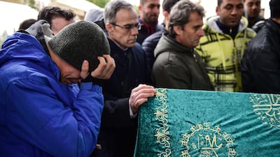 A mourner holds his head in his hands as he stands next to the coffin of victim Mohamed Elhot during his funeral ceremony on January 3, 2017, in Istanbul. Yasin Akgul/AFP