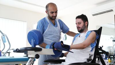 Mohammed Al Hosani takes part in a physiotherapy session with Ahmad Samour, a physiotherapist at the ProVita International Medical Center in Abu Dhabi. Pawan Singh / The National