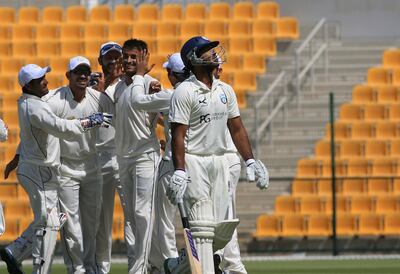 Then Afghanistan cricketer Izatullah Dawlatzai, centre, celebrates dismissing Scotland's Majid Haq at the ICC Intercontinental Cup in Abu Dhabi in 2012. Ravindranath K / The National