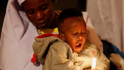 A worshipper and child during a new year's prayer at the St Joanes, Legio Maria of African Church Mission within Fort Jesus in Kibera district of Nairobi, Kenya. Reuters