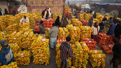 People buy oranges at a wholesale fruit market in Lahore, Pakistan. AP