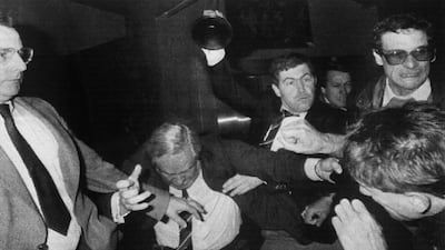 Jean-Marie Le Pen, president of the National Front, accompanied by a police officer, parries blows from protesters in Loiret, Orleans prefecture, in 1984. AFP