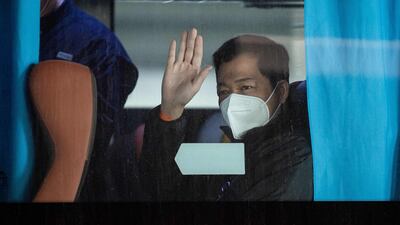 A member of the WHO team investigating the origins of the Covid-19 pandemic waves after boarding a bus following their arrival at a cordoned-off section in the international arrivals area at the airport in Wuhan. AFP
