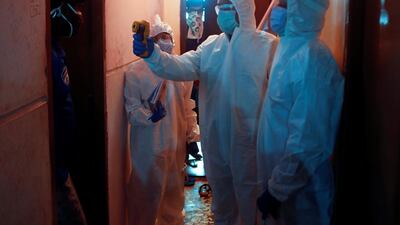 Health workers check the temperature of a resident at a housing society in Mumbai during a screening campaign for the coronavirus in India's financial capital. Reuters