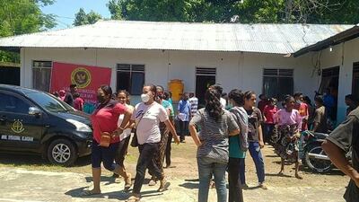 Villagers stand outside a building in Maumere in East Nusa Tenggara on Flores island on December 14, 2021, after a 7. 3-magnitude earthquake struck off the coast in eastern Indonesia. (Photo by YANUARIUS ARLINO WELIANTO / AFP)