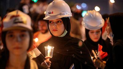 Iraqi women light candles for slain anti-government protesters during ongoing protests in Basra, Iraq. AP Photo