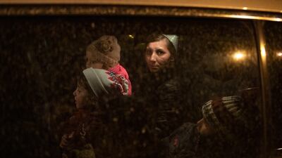 A woman from Ukraine sits in a car with her children as a volunteer takes them to a hostel in Budapest, Hungary. AP