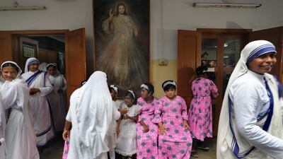 Nuns and children wait for the start of a mass prayer celebrating the 113th birth anniversary of Mother Teresa at the Mother House in Kolkata, India. EPA