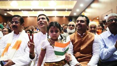 Proud Indians celebrate their country’s independence at the consulate in Bur Dubai on Friday. Amritha Lakshmi sits on the lap of her uncle, P K Patni, while her father, right, enjoys the show. Lee Hoagland / The National