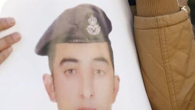 Anwar Al Tarawneh, the wife of Jordanian pilot Lt Maaz Al Kassasbeh, holds a poster of him as she weeps during a demonstration in Amman on February 3. Raad Adayleh / AP Photo