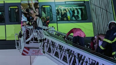 Emergency workers rescue passengers stranded after heavy rains disrupted train services in Mumbai. AP