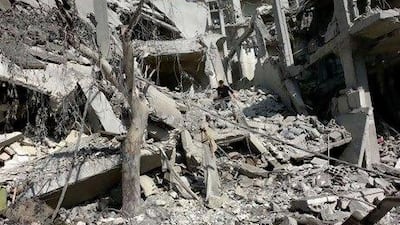 A Syrian man on the rubble of a destroyed building on the outskirts of Damascus.