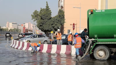 Workers at the under construction Dubai Metro site pump out the rain water with the help of water tankers at a street in Discovery Gardens. Pawan Singh / The National
