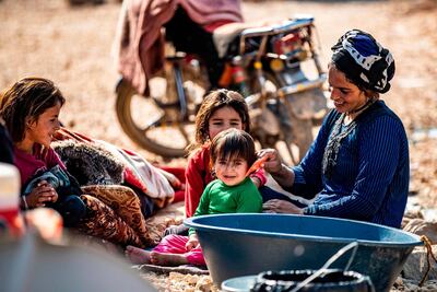 A Syrian woman amuses a child as others look on in the Washokani camp. AFP