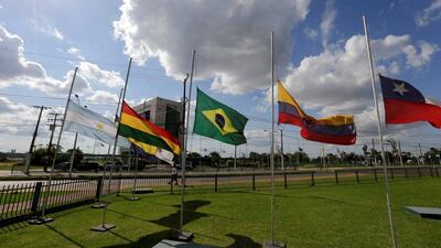The flags of Brazil and the member countries of the South American Football Confederation (Conmebol) fly at half staff at headquarters in Paraguay. Jorge Adorno / Reuters