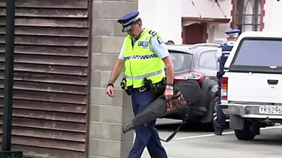 An officer carries a gun voluntarily handed in by a member of the public. TVNZ via AP