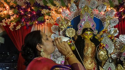 A devotee performs a ritual in front of the idol of Durga during Navratri and Durga puja celebrations in Ahmedabad. AFP