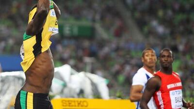 Usain Bolt, left, of Jamaica, pulls his shirt over his head after making a false start in the 100m final at the World Championships in Daegu.