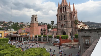 Tourists are seen on the main square in front of the San Miguel Arcangel cathedral on April 11, 2017 in San Miguel de Allende, Guanajuato state, Mexico. San Miguel De Allende, a town with Spanish Colonial architecture located in eastern Mexico, received a Travel + Leisure’s 2017 award as one of the World's Best Cities. / AFP PHOTO / YURI CORTEZ