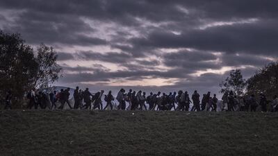 A handout image provided by the World Press Photo (WPP) organisation on 18 February 2016 shows a picture by Russian photographer Sergey Ponomarev for The New York Times that won First Prize Stories in the General News Category of the 59th annual World Press Photo Contest, it was announced by the WPP Foundation in Amsterdam, The Netherlands on 18 February 2016. The picture shows migrants walking atop a dyke as Slovenian riot police escorted them to a registration camp outside Dobova. War, drought and more are driving millions of people from their homelands. Under Europe’s system of open internal borders, the island’s thinly patrolled, easily accessible coastline, within sight of the Turkish coast, might as well be the frontier of France or Germany or Sweden. Sergey Ponomarev / EPA